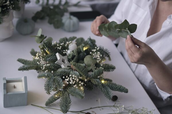 Woman decorated a Christmas table decoration. Hands close-up.